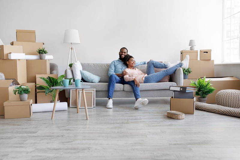 A couple lays on a couch after moving into a new home.