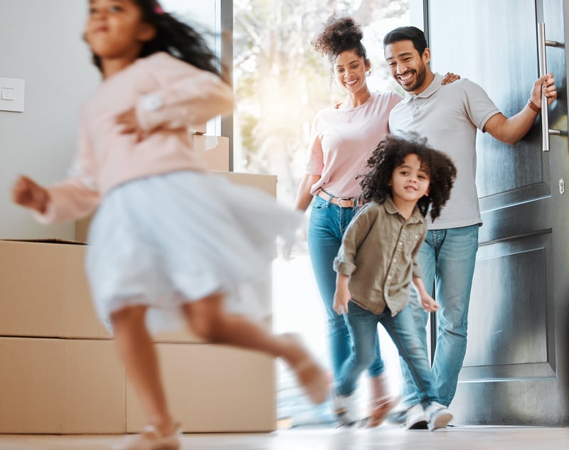 A family laughs while exploring their new home.
