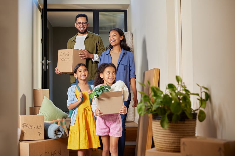 A family carries boxes into a new house.