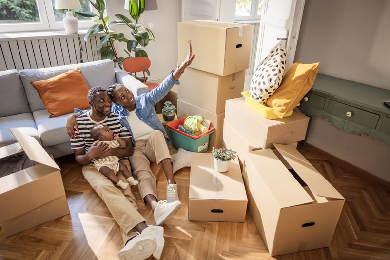 People lay on the floor surrounded by boxes while moving into a new house.