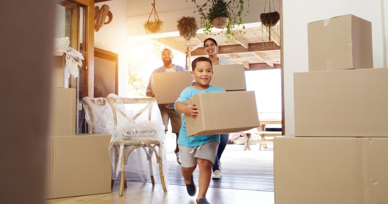 A family carries boxes into a new house.