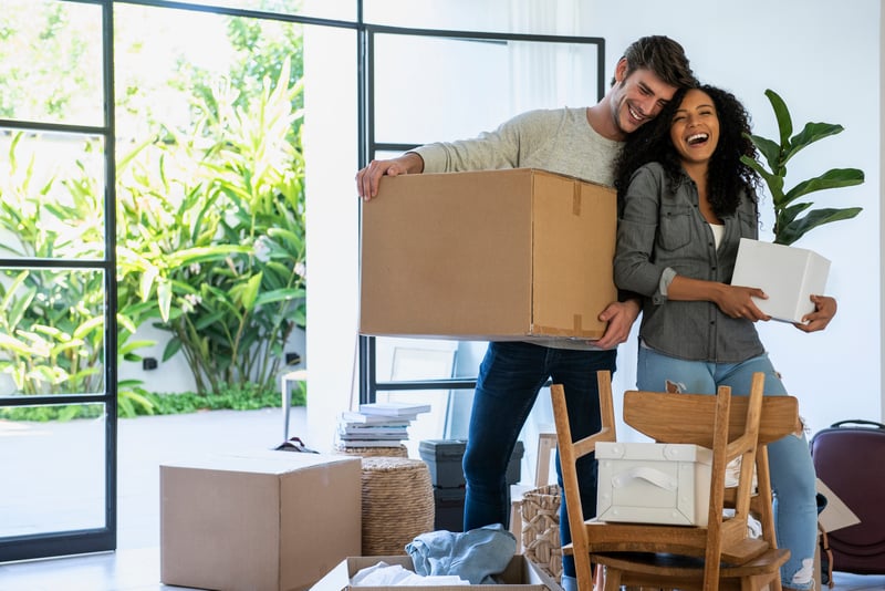 A couple moves boxes into their new home.