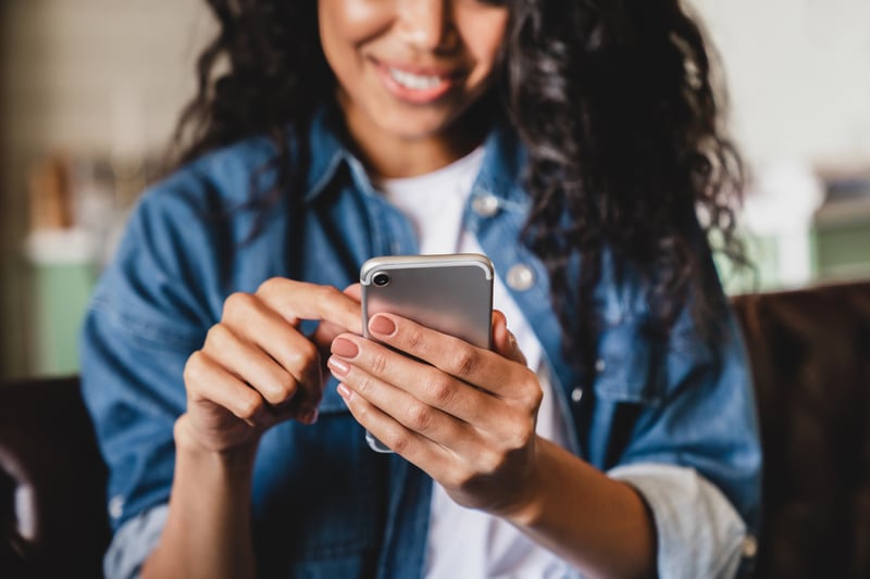 A woman smiles while looking at accessible loan options with poor credit.
