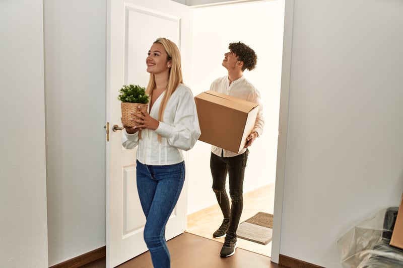People move boxes into a new house.