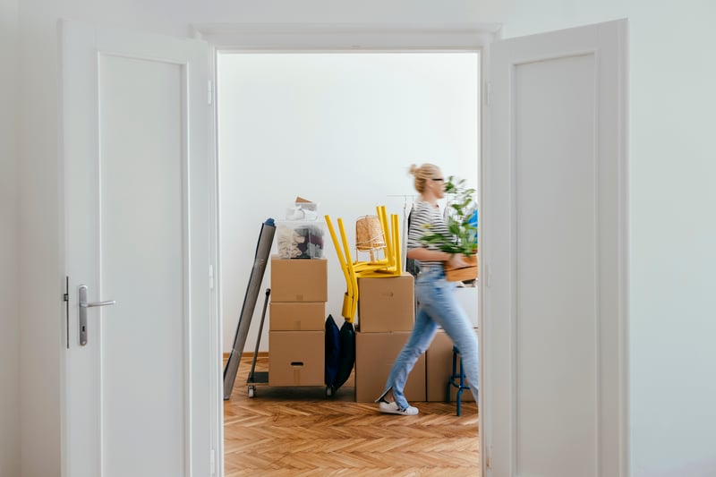 A woman unpacks boxes in her new home.