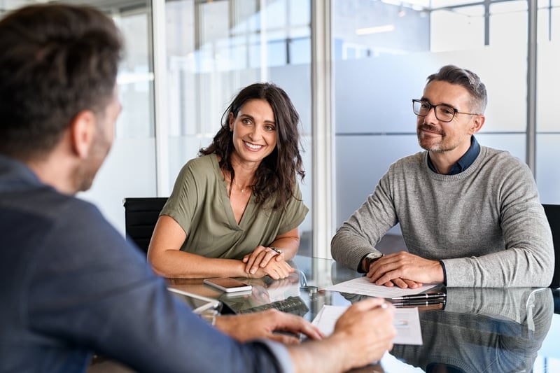 People speak with a loan officer about their options for buying an investment property.