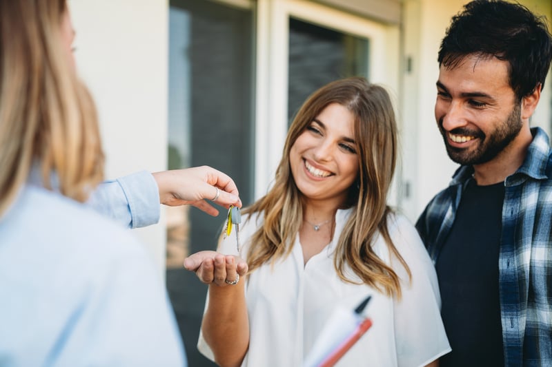 A couple smiles while getting the keys to their new home.