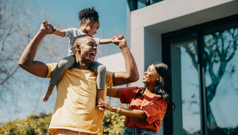 People smile outside of a new house.