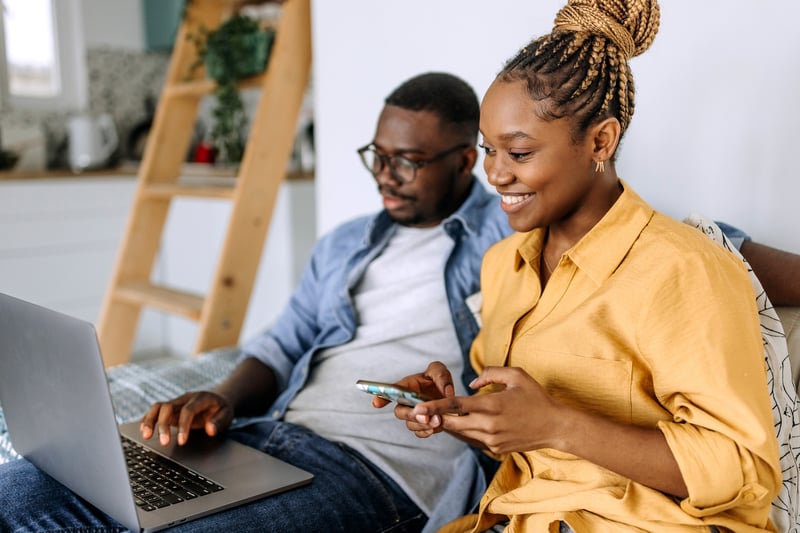 A man and a woman review Michigan refinance rates on a laptop.