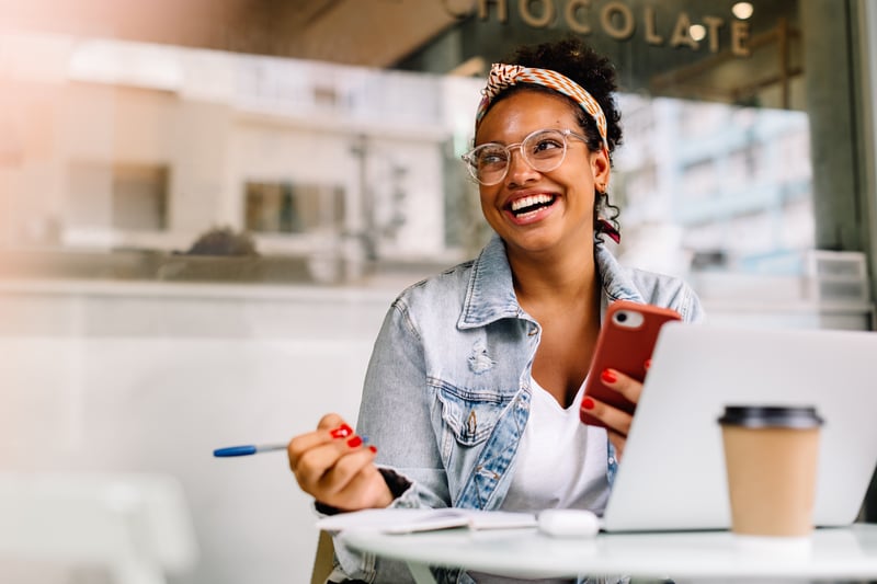 A woman smiles while comparing Loan Estimates.