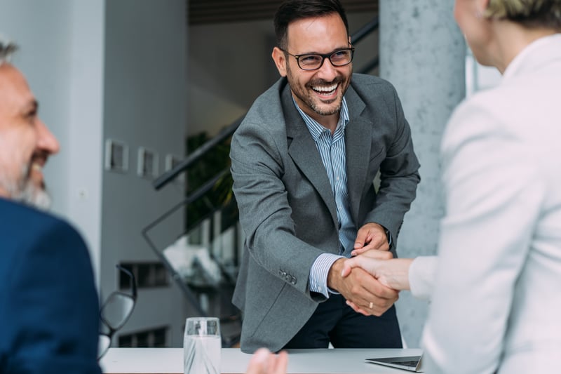 A man smiles while closing on a loan for an investment property.