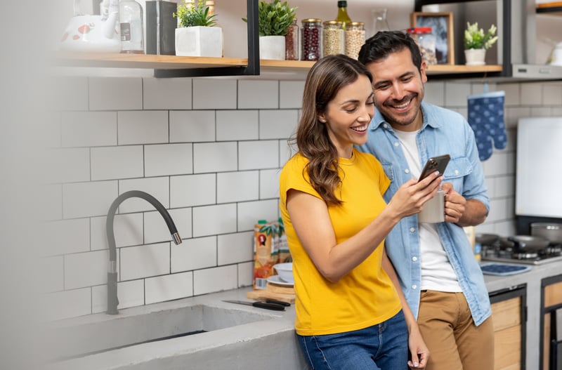 A man and a woman review Nebraska refinance rates on a cell phone.