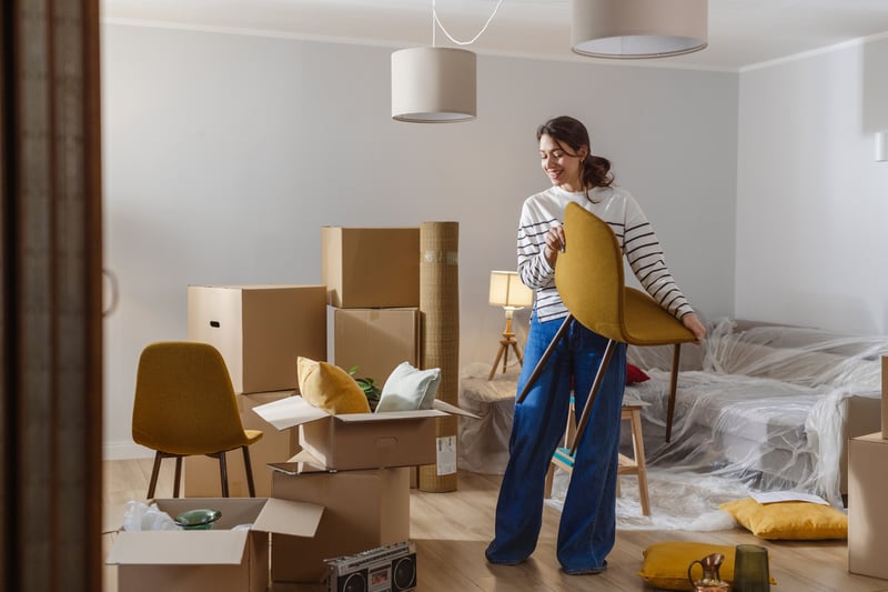 A woman moves a chair into a new house.