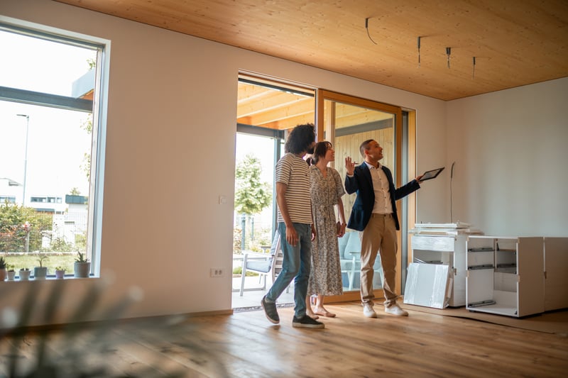 A couple tour a house with a real estate agent.