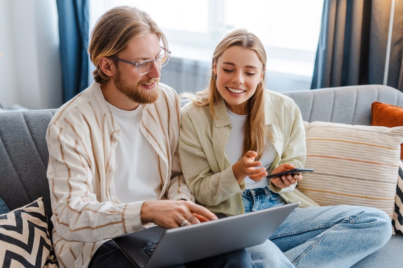 A man and a woman look at a laptop and compare different Nevada refinance products.