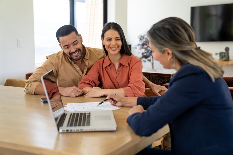 A man and woman speak with a loan officer.