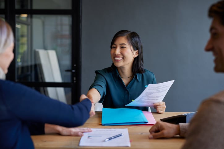 A woman smiles while discussing rate lock details with a loan officer.