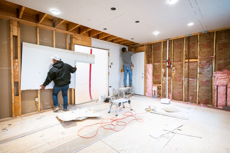 Workers hang up panels while renovating a house.