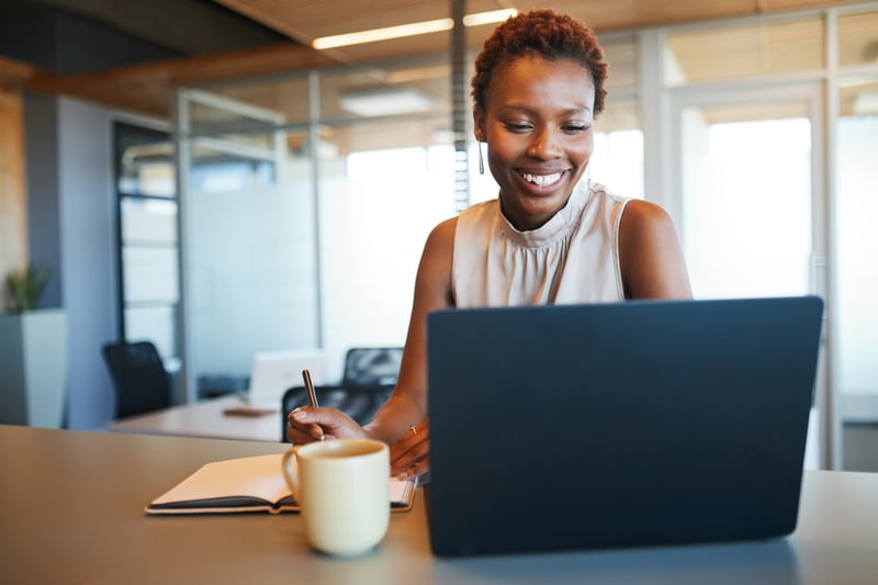 A woman smiles while looking at her FHA loan options.