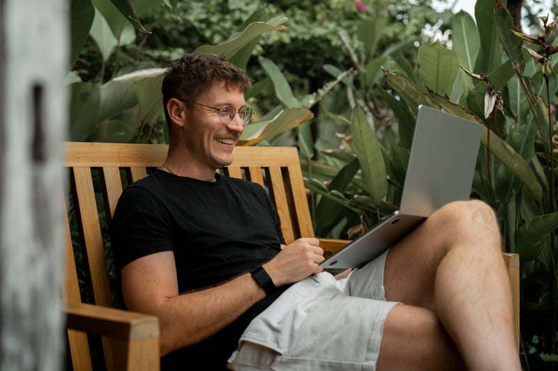 A man smiles at a laptop while shopping for a mortgage.