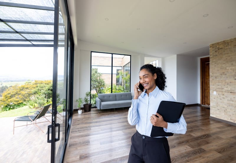 A self-employed borrower talks on the phone while touring a home. 