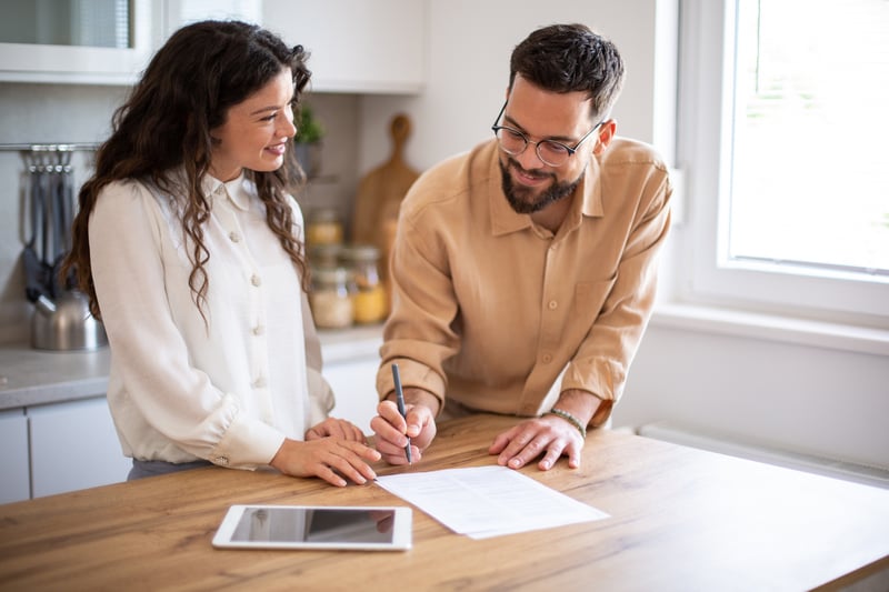 Borrowers smile while evaluating piggyback loan options.