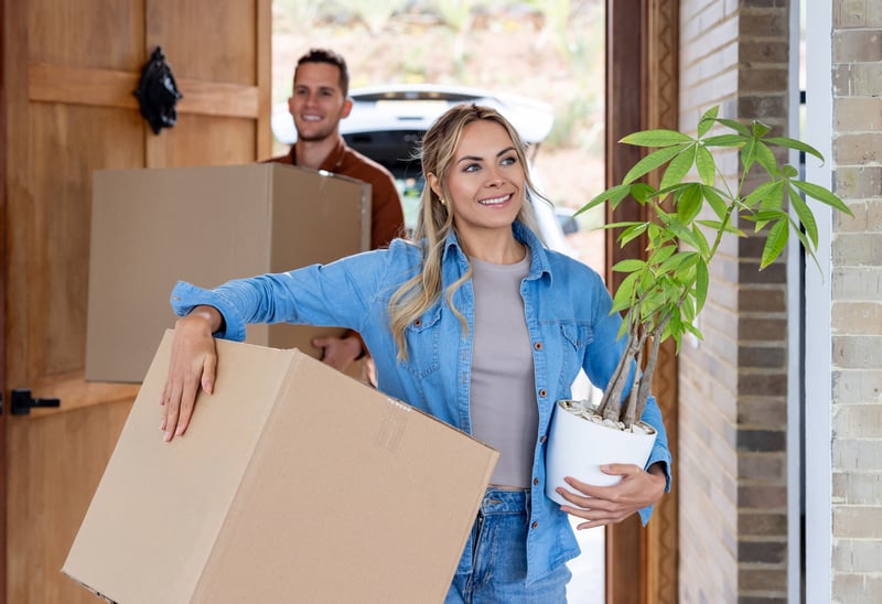 People smile while moving into a new house.