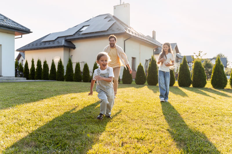 A young family stands on the lawn of their new second home.