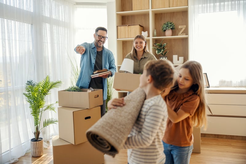 A family smiles while moving into a home purchased with a VA loan.