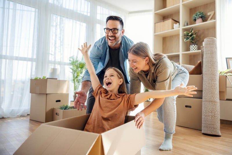 A family moves boxes into a new home.