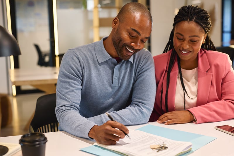 A couple smiles while closing on a refinance in Georgia.