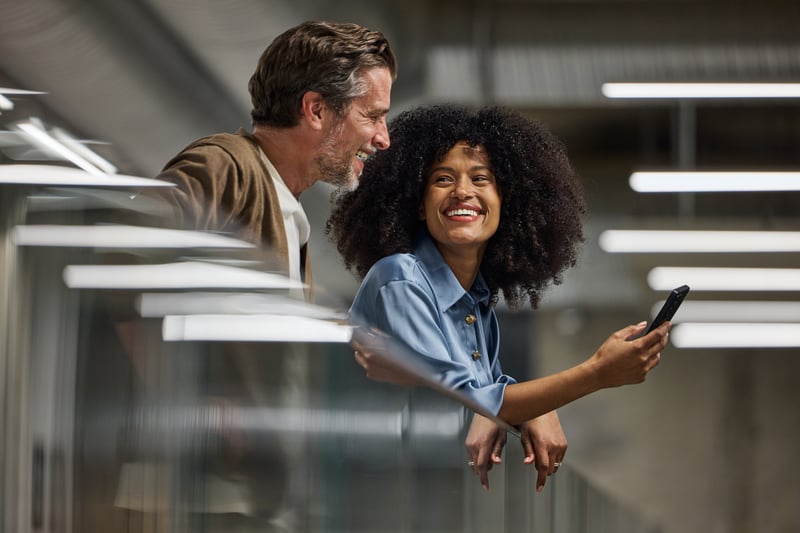 People smile at a cell phone while exploring Florida refinance rates.