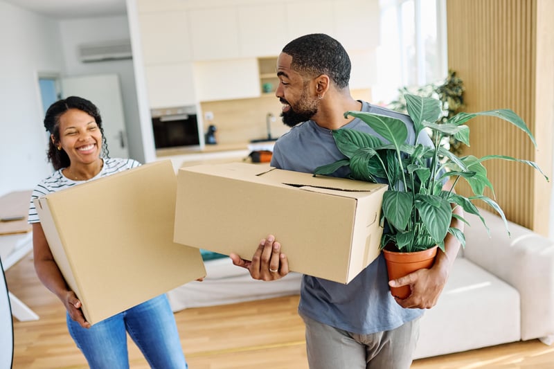 A man and woman smile while moving into a house in Florida.