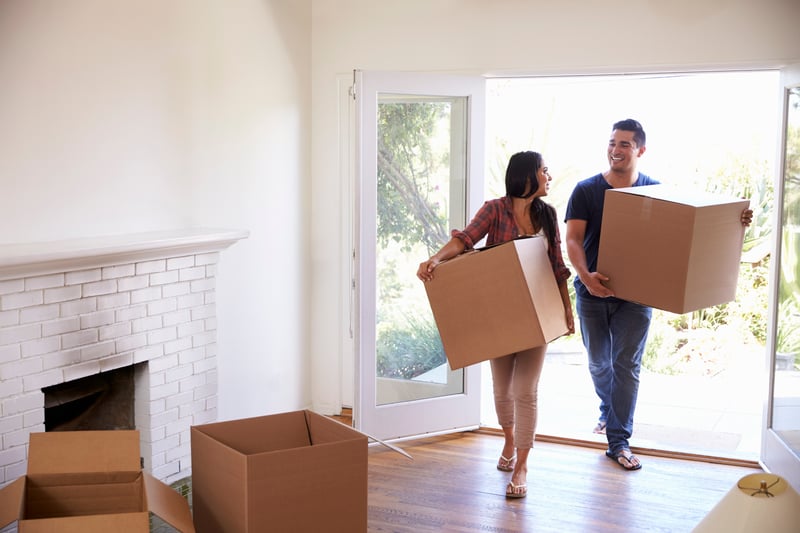 People smile while moving into a house purchased with a USDA loan.