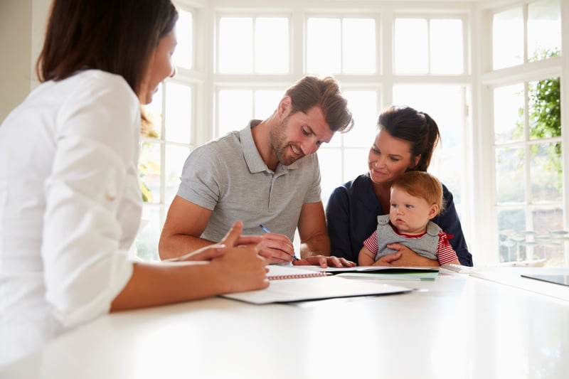 A family signs documents to assume a USDA loan.
