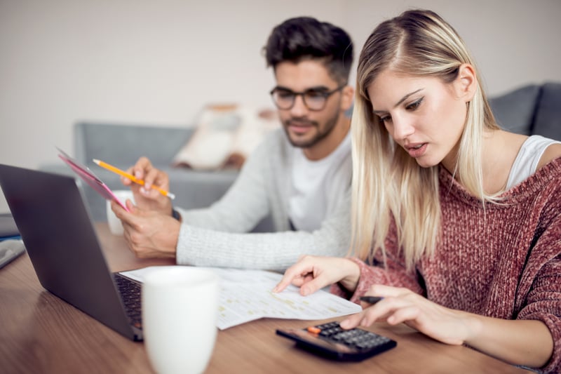 A man and woman go over their budget to see if  they can afford a $300,000 house.
