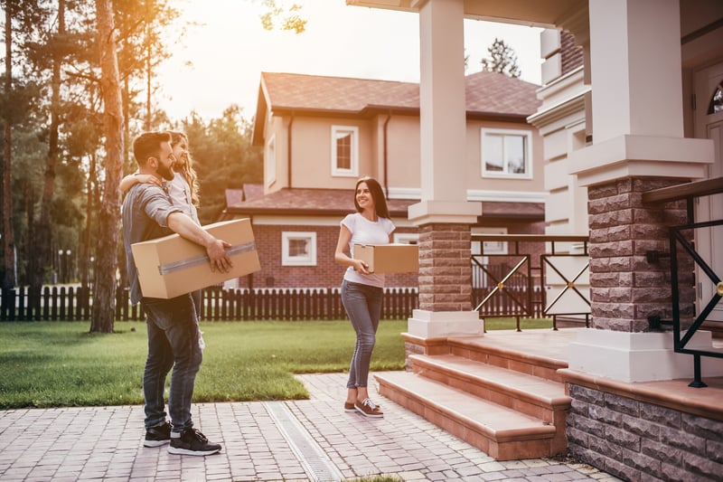 People carry boxes into a new house.