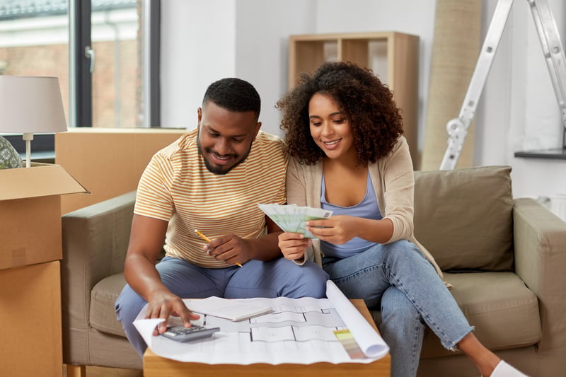 A man and a woman smile while planning renovations for their new home.