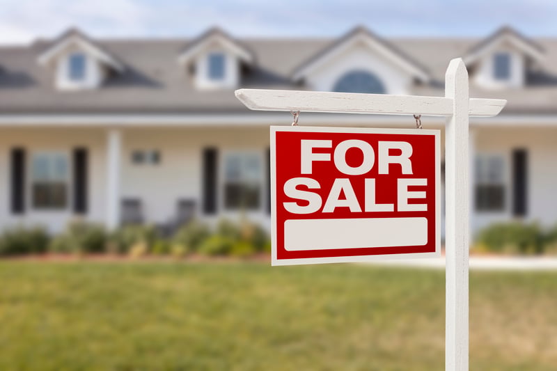 A for sale sign in front of a home.