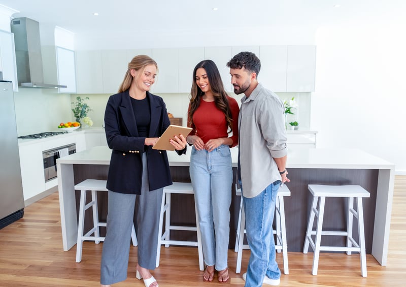 A man and a woman tour a house with a real estate agent.