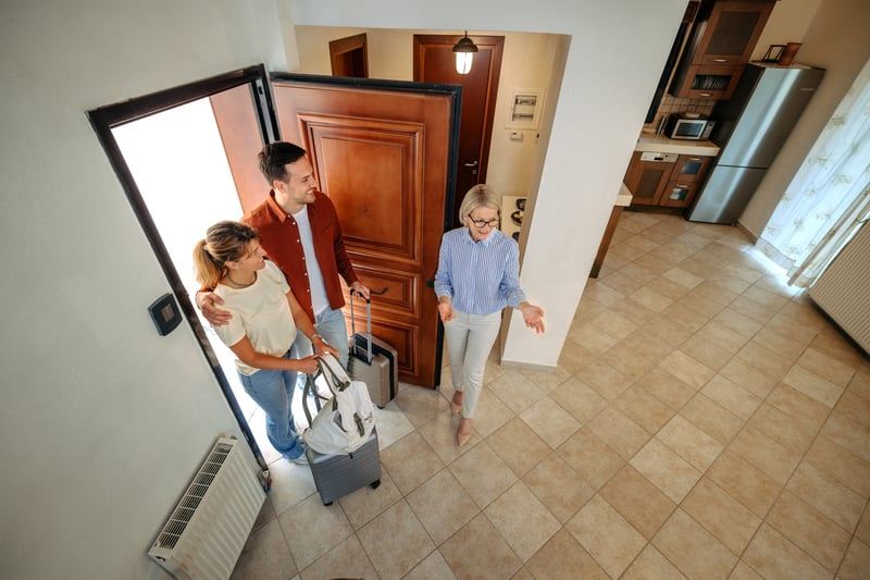 A man and a woman are shown a new house by a real estate agent.