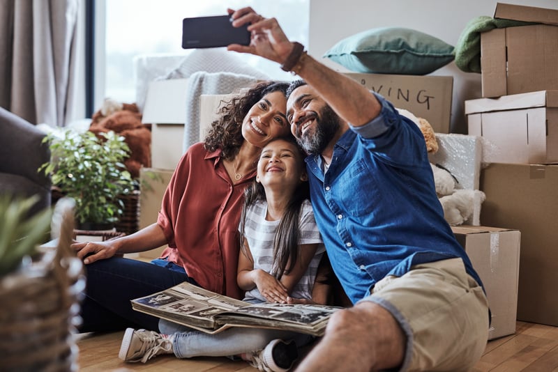 A family takes a selfie after moving into a new house.