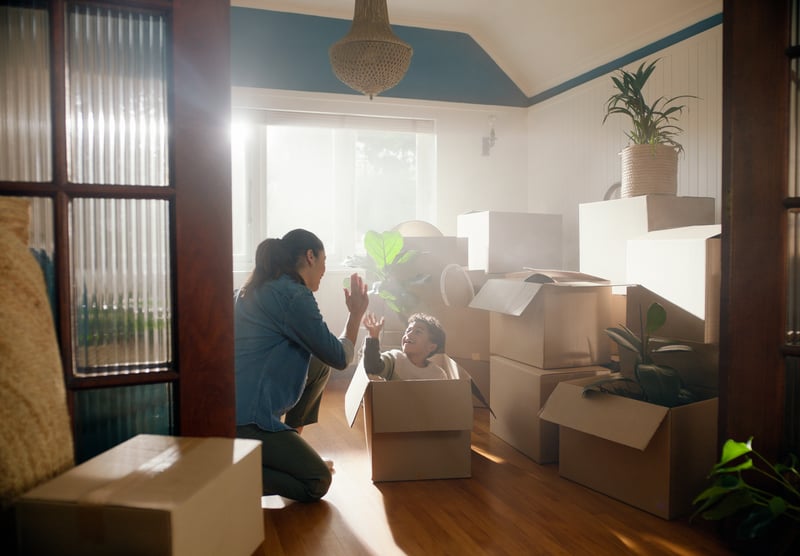 A veteran smiles while moving her child into a home purchased with a VA loan.