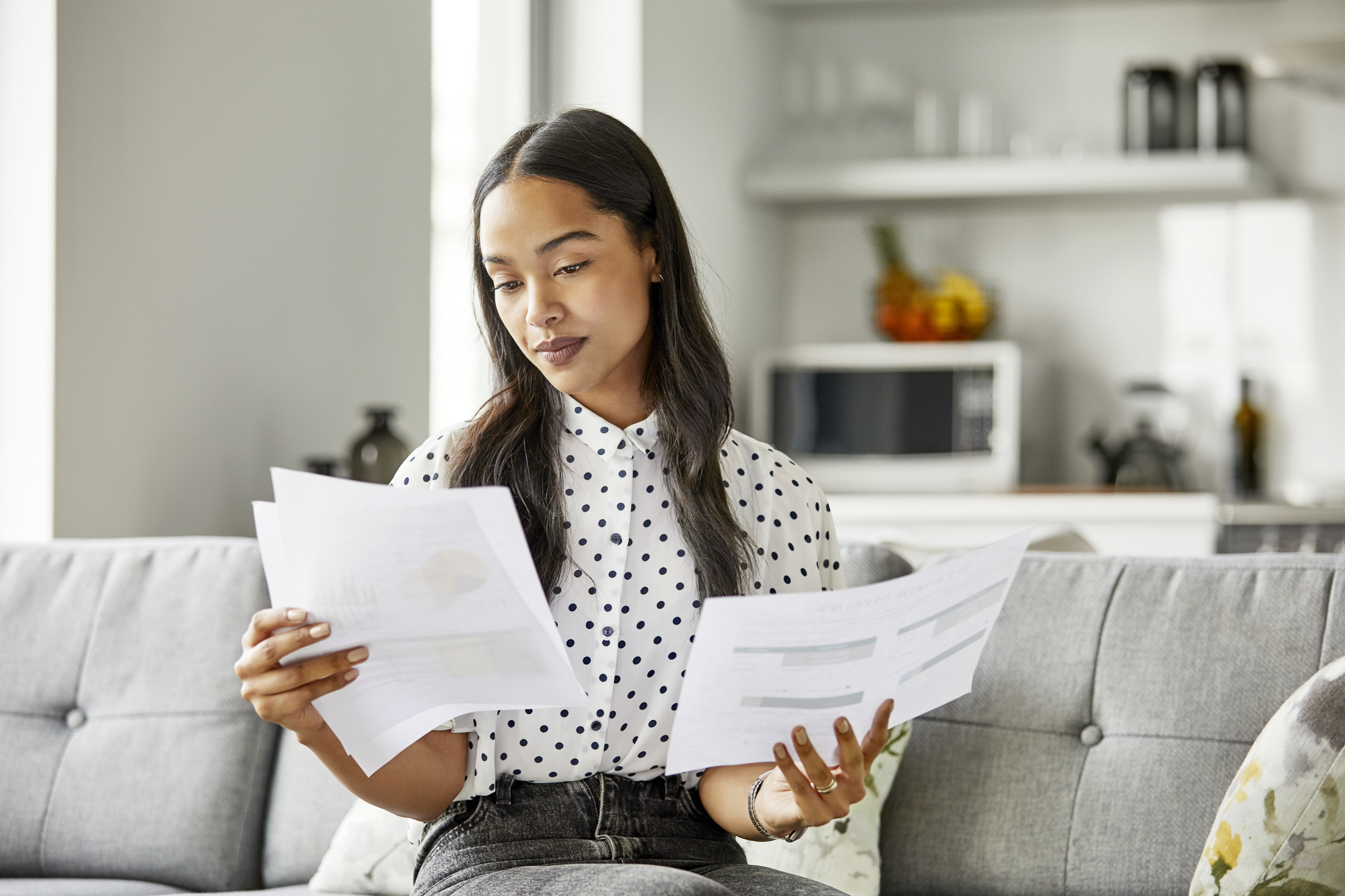 A woman compares financial documents.
