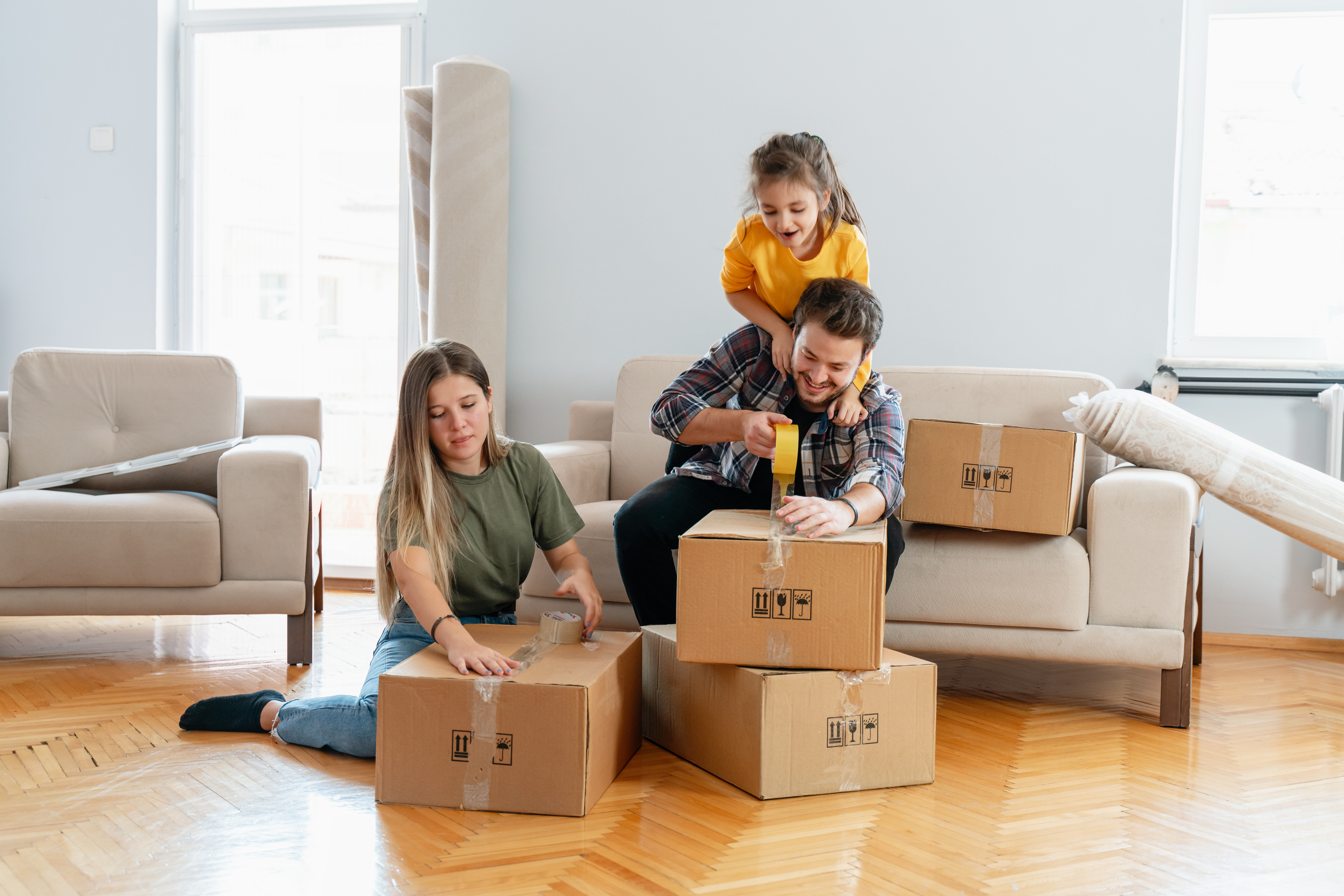 A man, woman, and child unpack boxes in their new home.