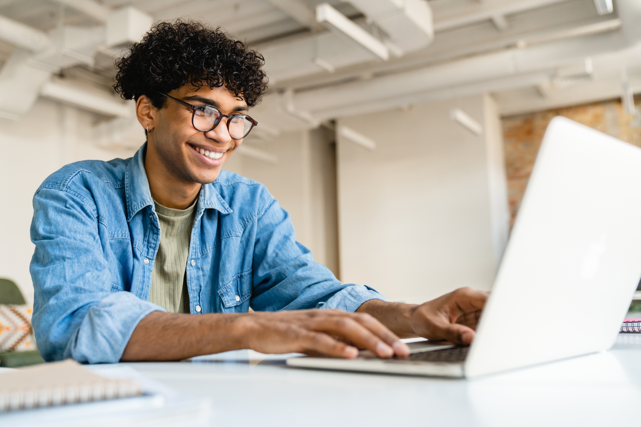 A person smiles at a laptop while using a custom mortgage calculator. 