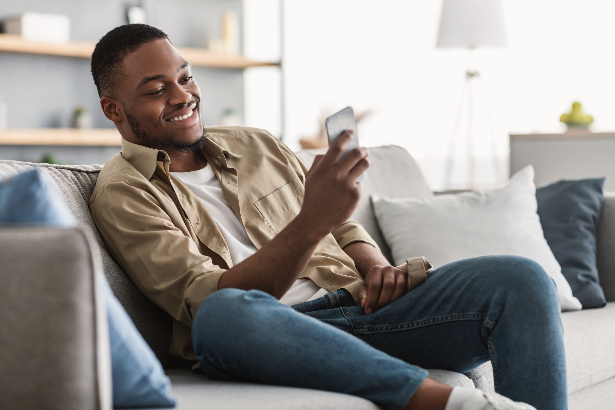 A man smiles at a phone while comparing temporary buydowns.