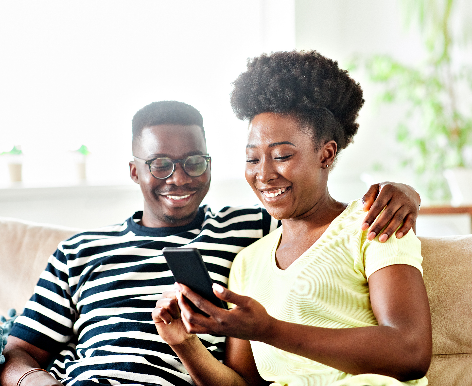 A man and a woman smiling at a phone.