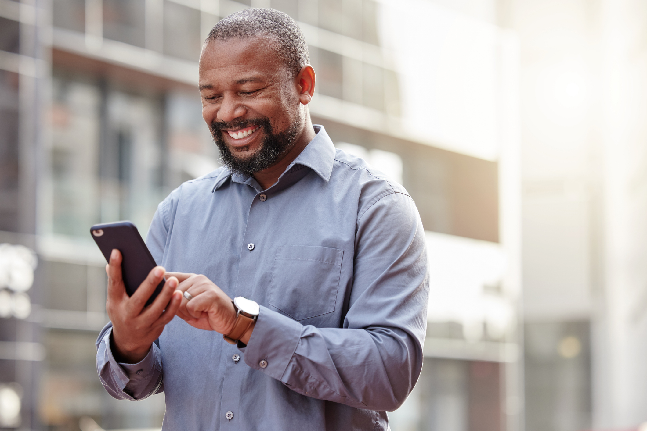 A man smiles at a phone.