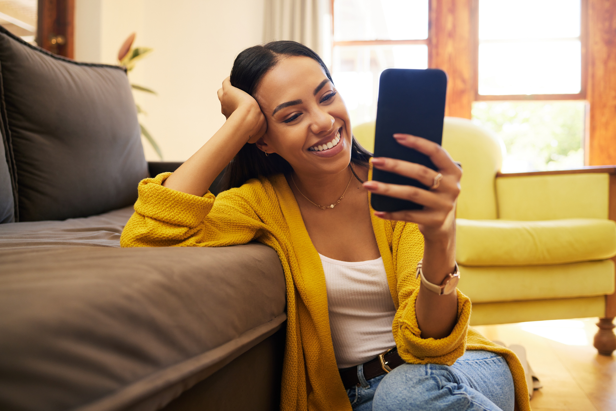 A woman smiles at a phone.